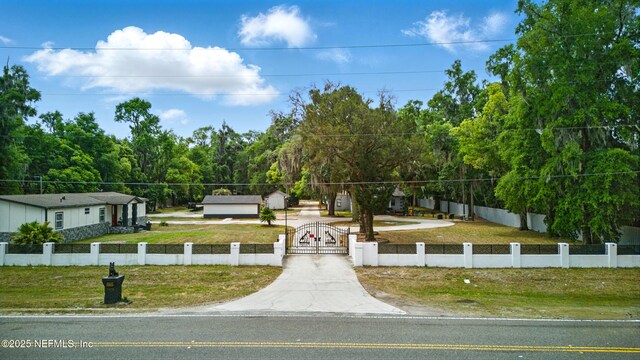 6878 Lenox Ave, Jacksonville, FL 32205 - view of front of house featuring a gate, a front lawn, a fenced front yard, and driveway