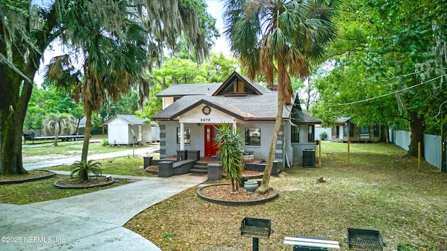 6878 Lenox Ave, Jacksonville, FL 32205 - bungalow with roof with shingles, a porch, a front lawn, and brick siding