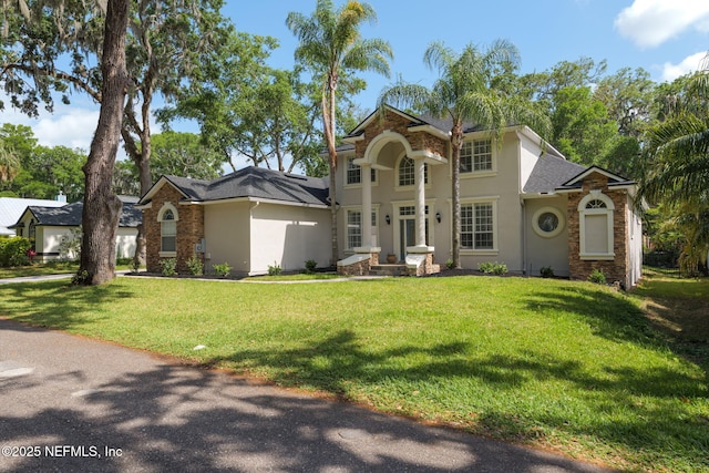 2762 Seagate Ave, Jacksonville Beach, FL 32250 - view of front facade with a shingled roof, a front lawn, and stucco siding