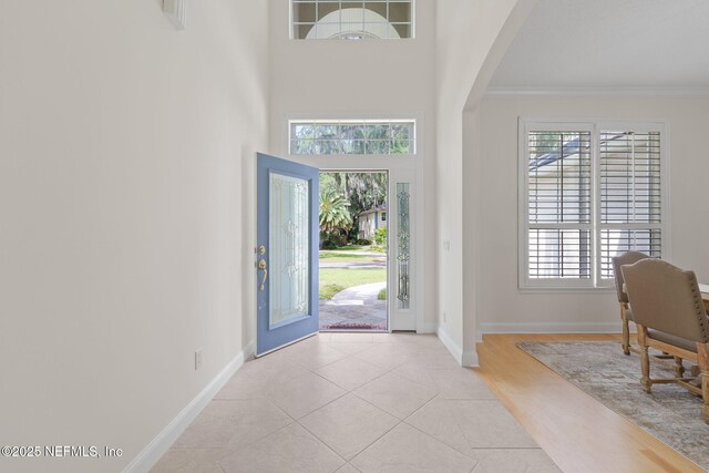2762 Seagate Ave, Jacksonville Beach, FL 32250 - tiled entryway with crown molding, arched walkways, baseboards, and a healthy amount of sunlight