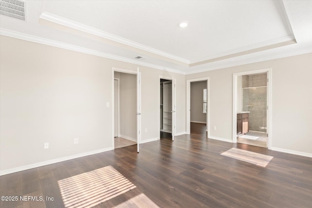 unfurnished bedroom with crown molding, a tray ceiling, and visible vents