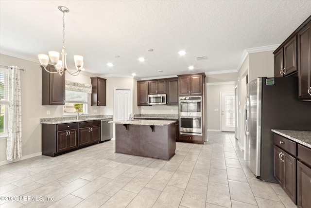 kitchen with visible vents, crown molding, a breakfast bar area, a center island with sink, and stainless steel appliances