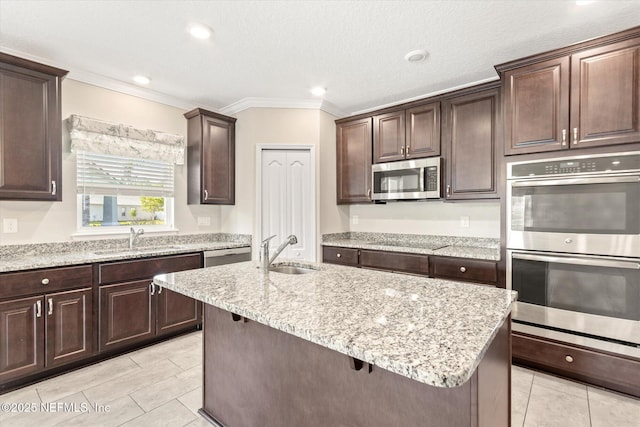kitchen featuring a sink, appliances with stainless steel finishes, crown molding, and light tile patterned floors