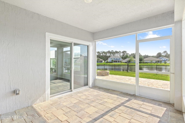 unfurnished sunroom featuring a water view