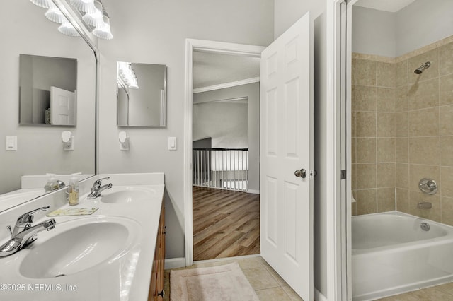 full bath with double vanity, shower / bathing tub combination, crown molding, a sink, and baseboards