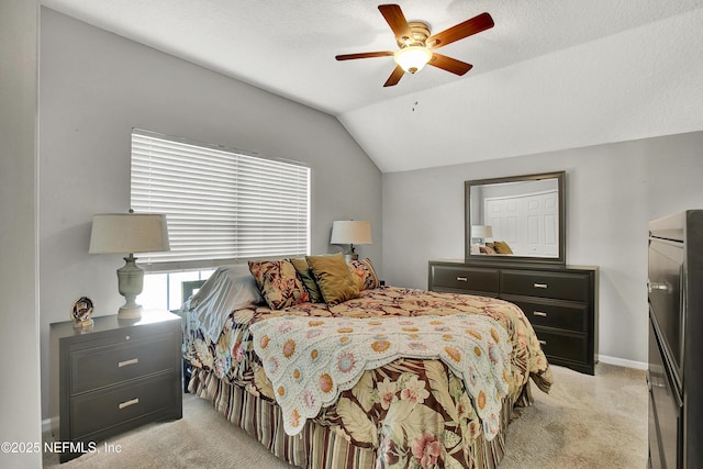 bedroom featuring light colored carpet, baseboards, ceiling fan, and lofted ceiling