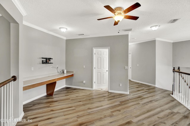 interior space with a ceiling fan, a textured ceiling, visible vents, and wood finished floors
