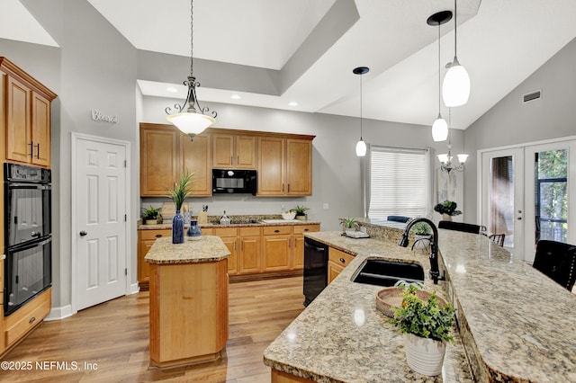 kitchen featuring visible vents, a spacious island, a sink, high vaulted ceiling, and black appliances