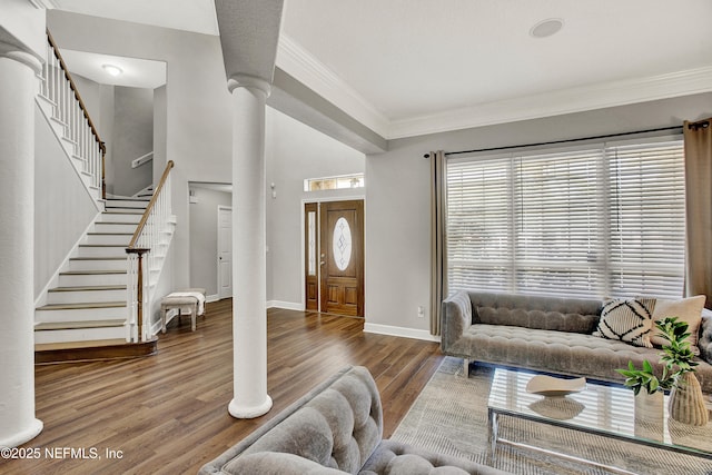 living area featuring crown molding, baseboards, wood finished floors, and stairway