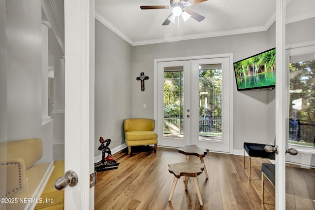 sitting room featuring crown molding, a ceiling fan, a healthy amount of sunlight, and french doors