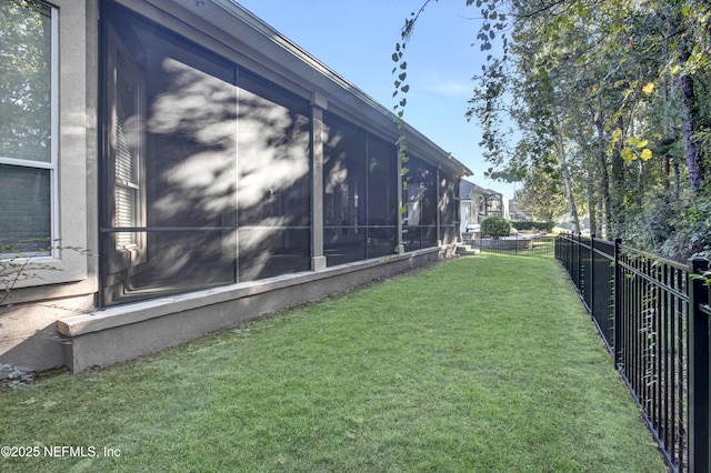 view of property exterior with a sunroom, fence, and a yard