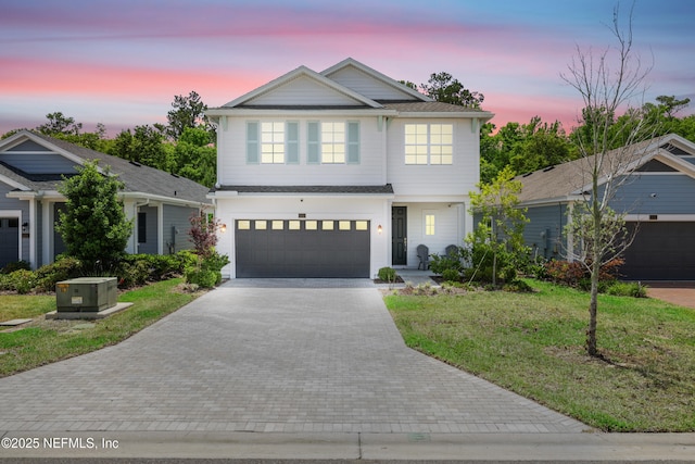 traditional-style house featuring a lawn, a garage, and driveway
