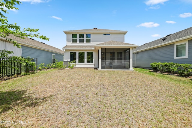 back of house with a lawn, a sunroom, a shingled roof, and fence