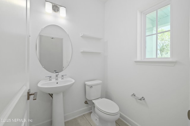 bathroom with a sink, tile patterned flooring, toilet, and baseboards