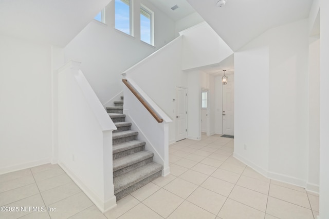 stairs with baseboards and tile patterned floors