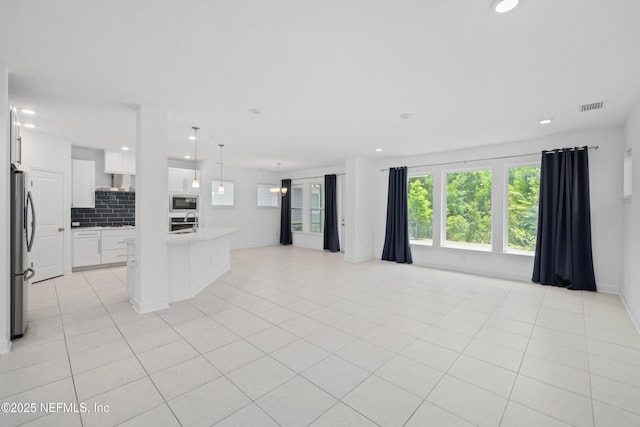unfurnished living room with recessed lighting, a healthy amount of sunlight, and visible vents