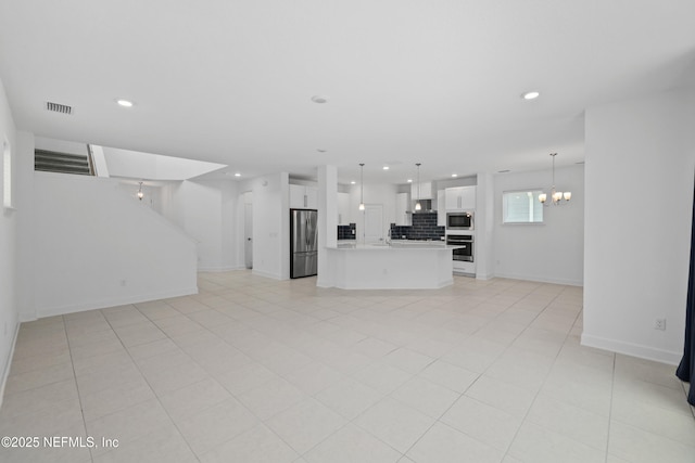 unfurnished living room featuring light tile patterned flooring, visible vents, recessed lighting, an inviting chandelier, and baseboards
