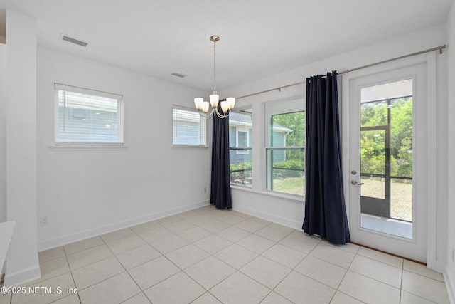 unfurnished dining area featuring baseboards, a notable chandelier, visible vents, and plenty of natural light