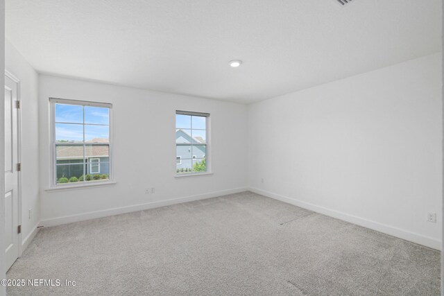 unfurnished room with baseboards and light carpet