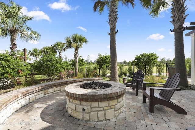 view of patio featuring an outdoor fire pit and fence