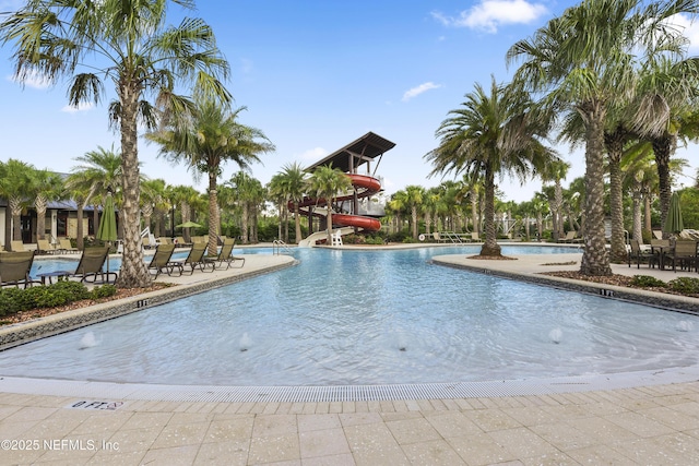 community pool with a patio and a water slide