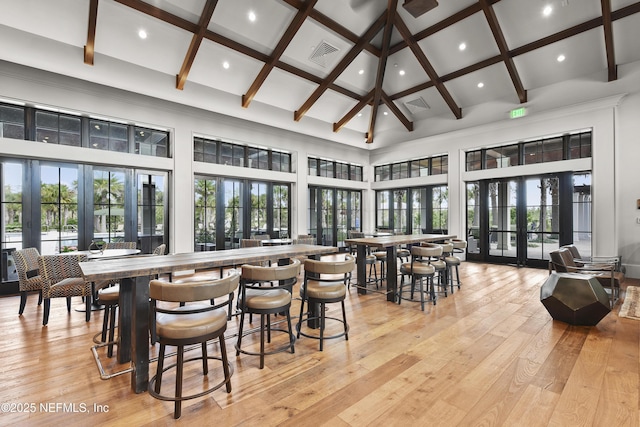 sunroom / solarium featuring beam ceiling, visible vents, and french doors