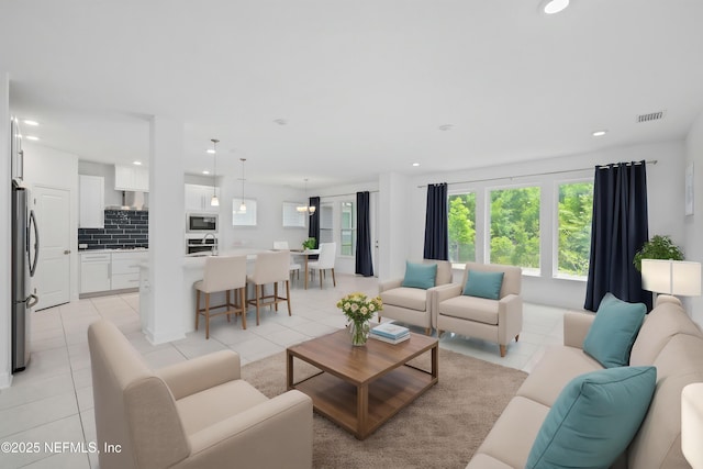 living area with light tile patterned flooring, visible vents, and recessed lighting
