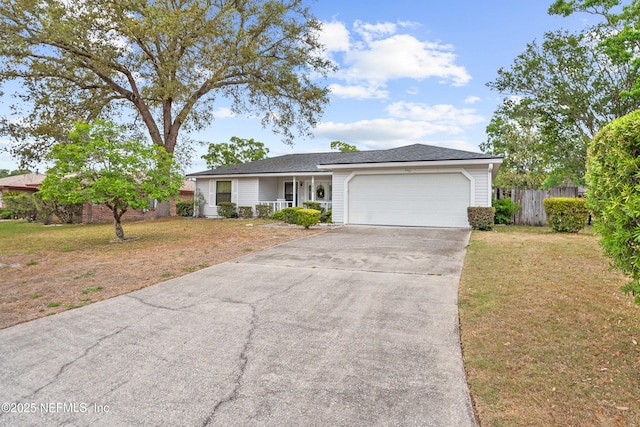 ranch-style house featuring fence, driveway, a front yard, and a garage