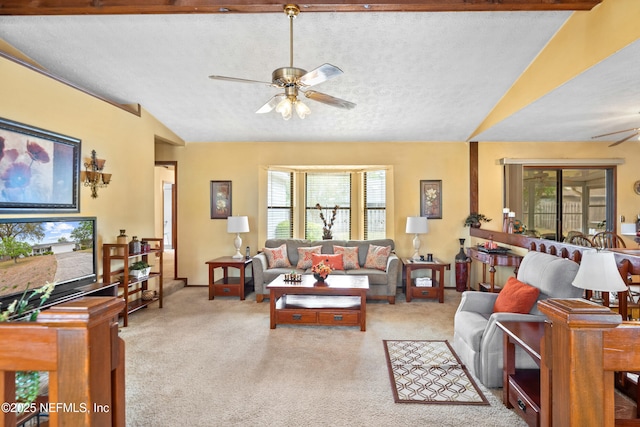 living area with carpet flooring, a ceiling fan, vaulted ceiling, and a healthy amount of sunlight