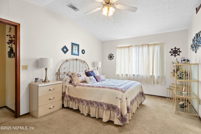 bedroom with a textured ceiling, vaulted ceiling, light colored carpet, and visible vents