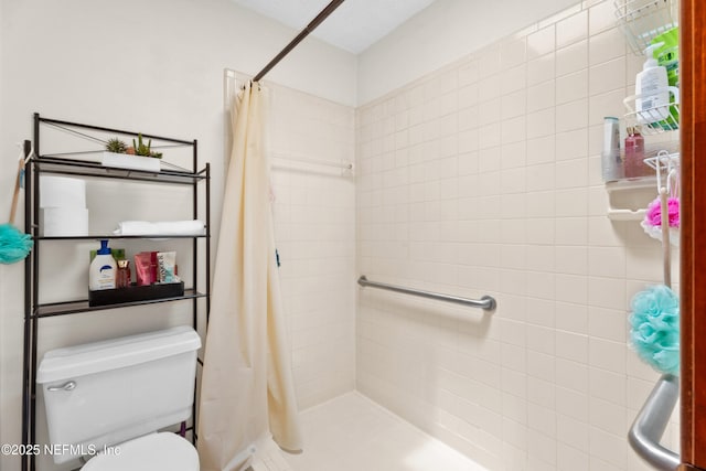 bathroom featuring a tile shower and toilet