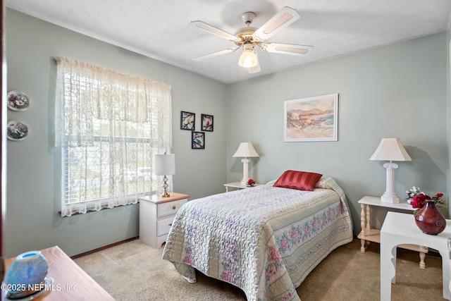 bedroom with light colored carpet, baseboards, ceiling fan, and multiple windows