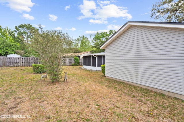 view of yard featuring fence and a sunroom