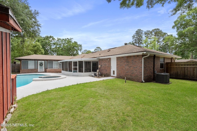 rear view of house with a patio area, a sunroom, central air condition unit, brick siding, and a fenced in pool