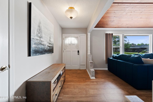 entryway featuring a textured ceiling, baseboards, and light wood-style flooring