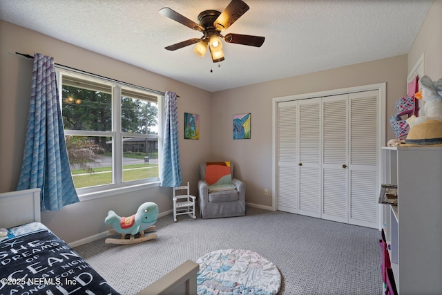 carpeted bedroom with a ceiling fan, baseboards, a textured ceiling, and a closet