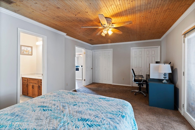 bedroom featuring carpet floors, ornamental molding, multiple closets, multiple windows, and ensuite bath