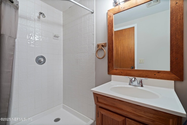 full bath featuring vanity, a stall shower, and visible vents