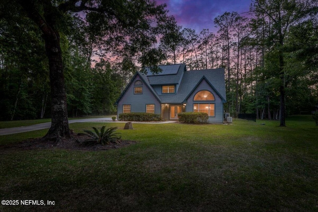 view of front of property featuring solar panels and a front yard