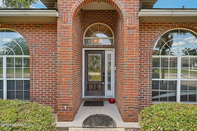 doorway to property with brick siding