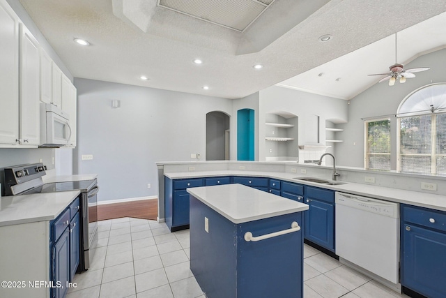 kitchen featuring a sink, white appliances, blue cabinetry, a center island, and a ceiling fan