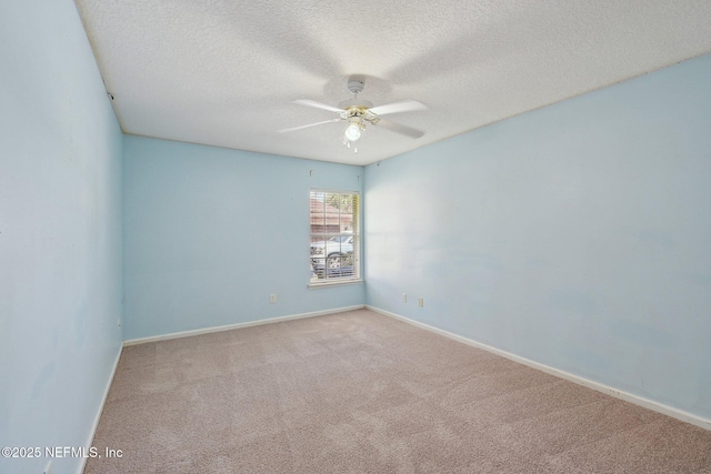 carpeted empty room featuring baseboards, a ceiling fan, and a textured ceiling