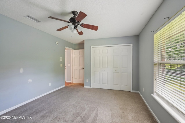 unfurnished bedroom with baseboards, carpet, a closet, and visible vents