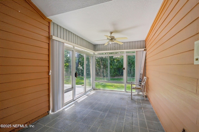 unfurnished sunroom with ceiling fan