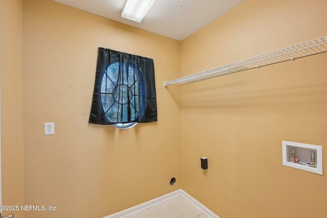 laundry room featuring laundry area, a textured ceiling, washer hookup, and baseboards