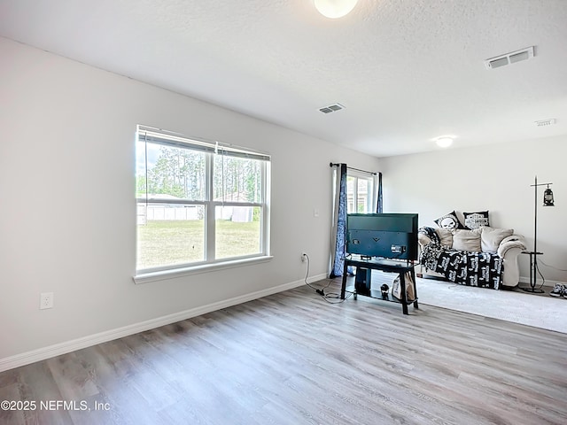 sitting room featuring baseboards, visible vents, and wood finished floors