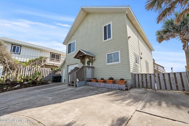 3365 N Ocean Shore Blvd, Flagler Beach, FL 32136 - rear view of house with fence, an attached garage, and concrete driveway