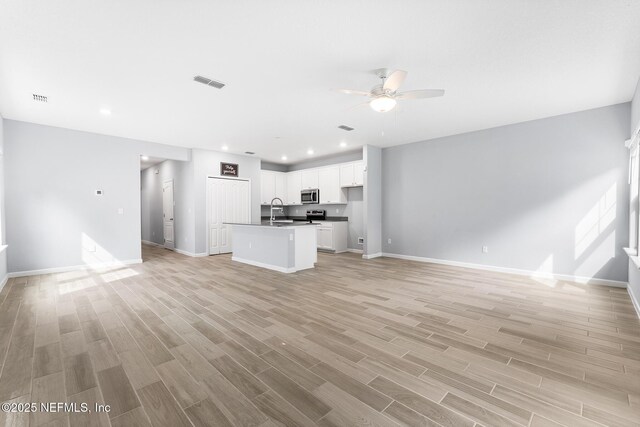10318 Benson Lake Dr, Jacksonville, FL 32222 - unfurnished living room with a sink, ceiling fan, baseboards, light wood-style floors, and recessed lighting