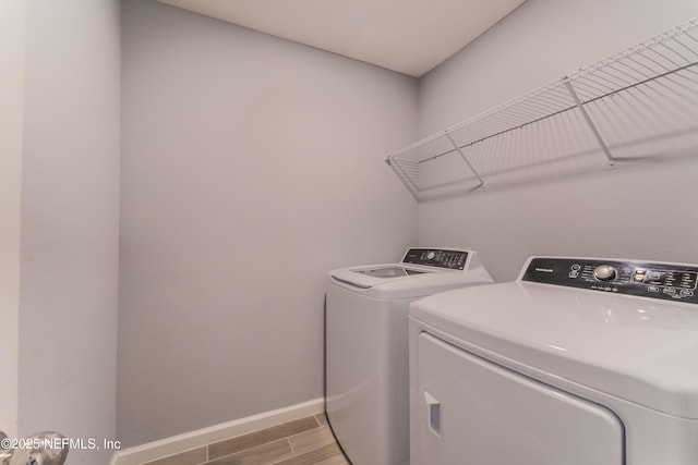 10318 Benson Lake Dr, Jacksonville, FL 32222 - washroom with washer and clothes dryer, baseboards, and wood finished floors