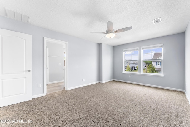 10318 Benson Lake Dr, Jacksonville, FL 32222 - empty room with carpet floors, a ceiling fan, a textured ceiling, and baseboards